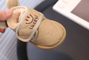 Close-up detail of warm faux fur lining on kids' beige snow boots with Lucky embroidery