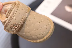 Close-up van beige gewatteerde babysneeuwlaarzen met warme bontvoering en dubbele gesp
