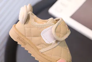 Detail of beige quilted toddler snow boots with warm fleece lining and Velcro strap