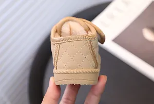 Gedetailleerde weergave van beige baby winterlaars hak met ruitpatroon en pluche voering