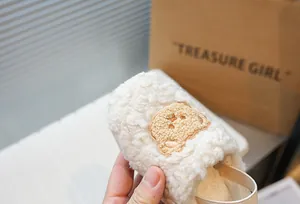 Vista dettagliata della scarpa primi passi in morbido peluche con ricamo a forma di orso