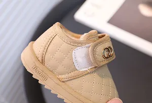 Close-up van gewatteerde babywinterlaars met goudkleurig ringdetail op de riem