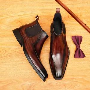 Botas Chelsea de cuero marrón pulido a mano con punta afilada y elegante grabado