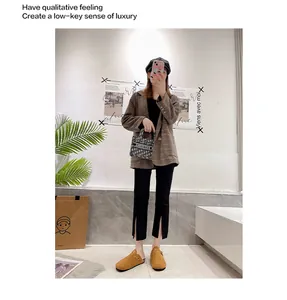 Lifestyle-Aufnahme von braunen Wildleder-Korkclogs mit warmem Futter und Schlitzhose