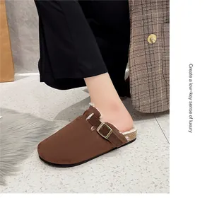 Detailansicht brauner Wildleder-Clogs mit Fleece-Futter und dekorativem Metallschnallenriemen