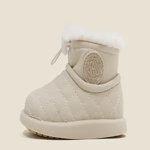 Primer plano de las botas de nieve acolchadas beige para bebé con forro de piel