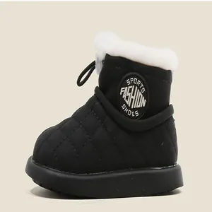 Primer plano de botas de nieve negras para bebé con forro de piel sintética blanca