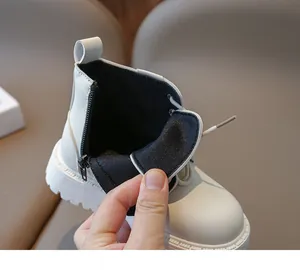 Gros plan détaillé de la fermeture éclair latérale sur les bottines Martin en cuir blanc pour enfant
