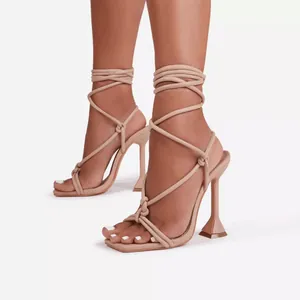 Detailed view of beige lace-up high heel sandals with an architectural stiletto heel.