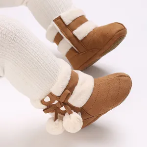 Detailed macro view of plush-lined baby winter boots with pom-pom accents
