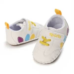 Dettaglio scarpe primi passi bianche per neonato con cinturino velcro e inserti colorati