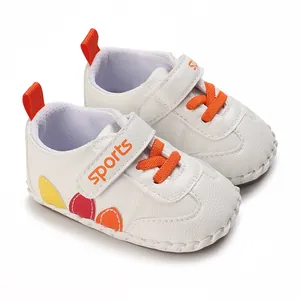 Vista dettagliata di scarpe da camminata bianche per neonati con lacci arancio
