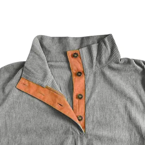 Primer plano de sudadera de pana gris para hombre con cuello alto en contraste naranja.
