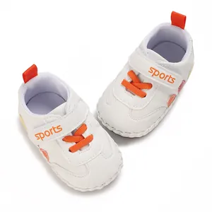 Vista dettagliata di scarpine primi passi bianche per neonati con lacci arancioni e velcro