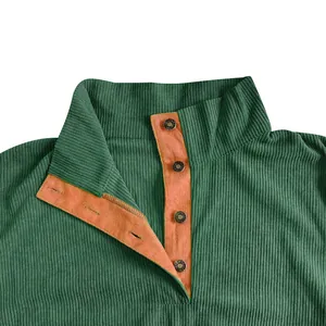 Primer plano del cuello de pana con tapeta de botones naranja y botones metálicos