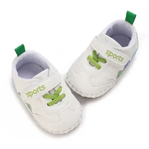 Vista dettagliata di scarpe bianche per primi passi neonato con lacci verdi e velcro
