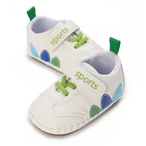 Scarpe primi passi per neonati in ecopelle bianca con dettagli verdi.