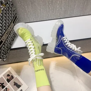 Detailed view of trendy transparent PVC lace-up boots paired with vibrant neon socks