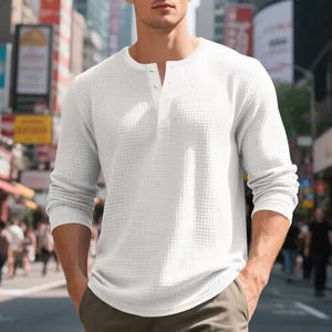 Detalle de camiseta Henley blanca de punto gofrado con manga larga y botones al cuello.