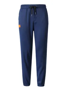 Vista frontal completa de los pantalones deportivos azul marino con detalle logo naranja.