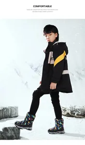 Boy wearing colorful patterned snow boots in a snowy mountain landscape