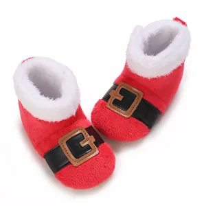 Detail van warme rode pluche baby laarsjes in kerstman stijl met witte imitatiebont rand.