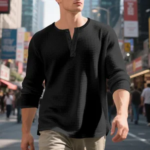 Primer plano de la textura de punto gofrado negro de una camiseta Henley de manga larga