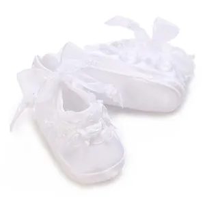 Detailed view of white baby princess shoes with elegant lace flowers and silk ribbon bows.
