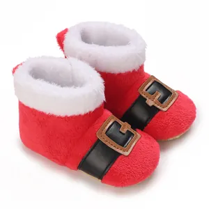 Detail van rode kerstbabylaarsjes met witte pluizige rand en een decoratieve riemgesp