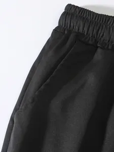 Vista detallada de la cintura elástica y el bolsillo lateral del pantalón cargo negro de hombre