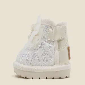 Detail view of sparkly white baby girl princess snow boots with elegant flower