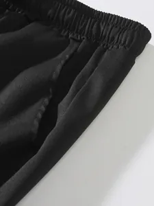 Primer plano de la cintura elástica y el bolsillo lateral de los pantalones cargo negros hombre