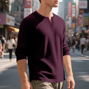 Primer plano de la textura de punto gofrado granate en una camiseta Henley de manga larga