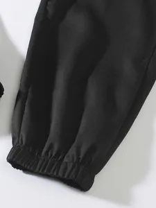 Primer plano del detalle del puño elástico en el tobillo de unos pantalones cargo negros para hombre