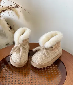 Detailansicht der cremefarbenen Mädchen-Schneestiefel mit Plüschfutter und Schleife