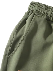 Detalle macro de pantalones cargo verde oliva para hombre con pretina y bolsillo
