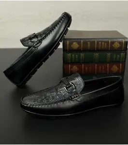 Detailtextur von schwarzen Leder-Loafern mit Krokodilprägung und Metallschnalle