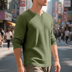 Vista detallada del tejido de punto gofrado verde oliva y la tapeta de botones de esta camisa Henley