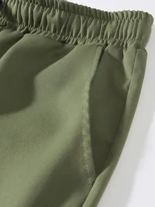 Primer plano detallado de pantalones cargo verde oliva con cintura elástica y bolsillo