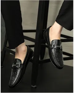 Nahaufnahme von Herren-Loafers aus schwarzem Leder mit Krokoprägung und Schnalle