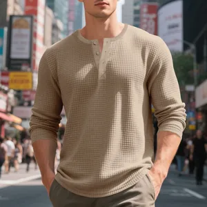 Close-up detail of the textured waffle knit fabric and buttons on a khaki Henley shirt