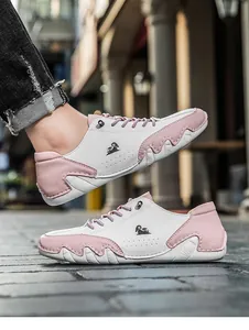 Detailed side view of pink and white casual sneakers featuring octopus-style rubber soles.
