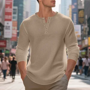 Detalle del tejido gofrado beige y el cuello con botones de una camiseta tipo Henley