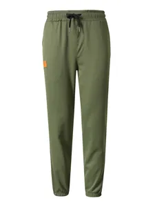 Vista detallada del pantalón cargo verde oliva para hombre con cordón negro y parche naranja