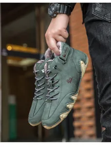 Close-up detail of green high-top men's winter boots featuring warm faux-fur lining and logo