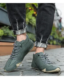 Detail of men's green high-top winter boots with warm lining on a city street.