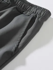 Detalle de la cintura elástica y el bolsillo lateral en pantalones cargo gris oscuro