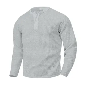 Camiseta Henley gris de manga larga con patrón de gofre detallado y cuello con botones.