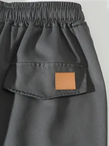 Detalle de la cintura y bolsillo trasero con parche decorativo en pantalones cargo