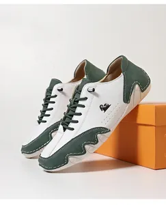 Close-up detail of white and green leather casual shoes showcasing the side logo and sole